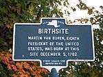 bronze marker with a map of the State of New York at the top, under 